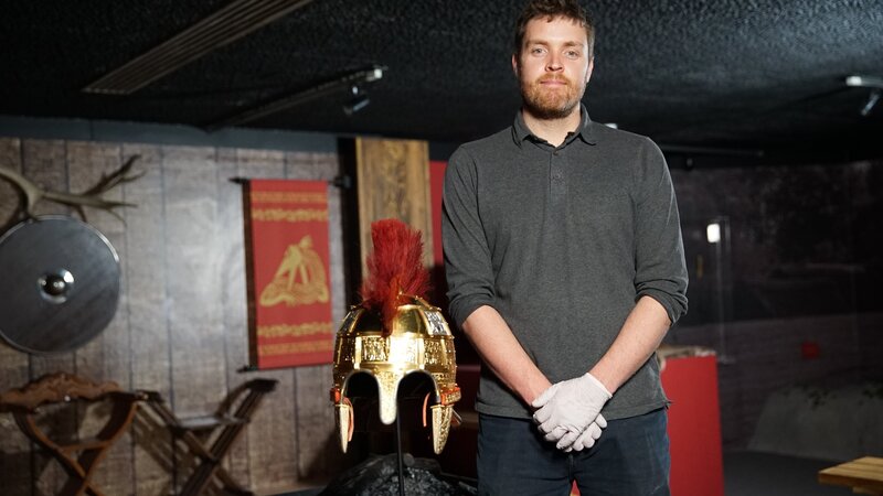 Kurator Joe Perry und ein rekonstruierter angelsächsischer Kriegerhelm. – Bild: Windfall Films Ltd.