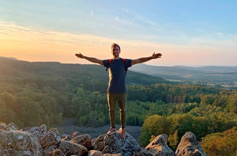Das Land der „offenen Fernen“: Daniel Aßmann genießt den Sonnenuntergang in der Rhön. – Bild: ZDF und WDR/​Bavaria Entertainment GmbH