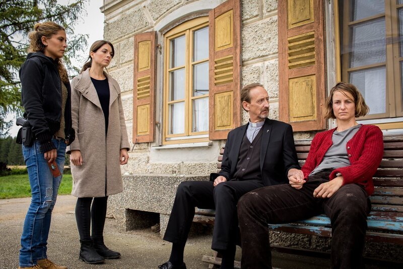 Toni Bischoff (Amanda da Gloria, l.) und Katharina Hahn (Bianca Hein, 2.v.l.) sprechen mit Ida Raininger (Lara Joy Körner, r.) während diese von Pfarrer Schwarz (Gilbert von Sohlern, 2.v.r.) getröstet wird. – Bild: ZDF und MARKUS SAPPER