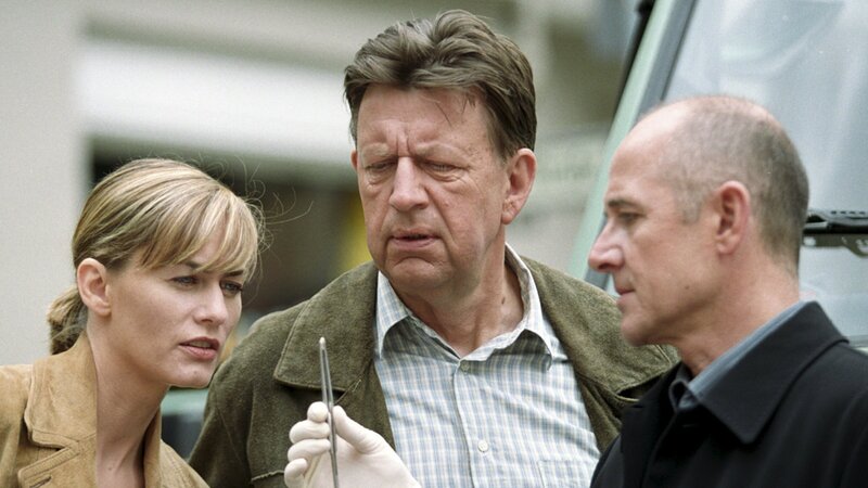 Am Mantel der Toten entdeckt Dr. Robert Kolmaar (Ulrich Mühe, r.) Maden, die er im Labor analysieren will. Judith Sommer (Gesine Cukrowski, l.) und Joe Hoffer (Jörg Gudzuhn, M.) schauen sich ebenfalls die Made genauer an. – Bild: ZDF