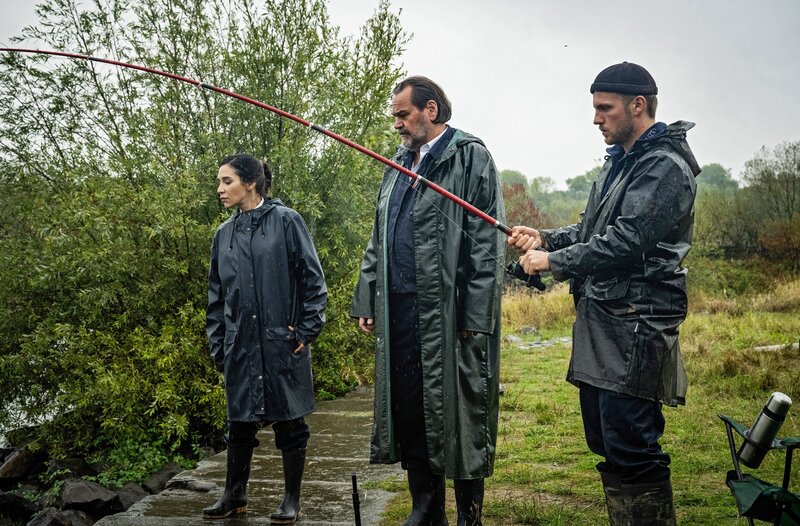 Arda (Yasemin Cetinkaya, l.) und Frank (Niklas Osterloh, r.) schauen sich gemeinsam mit Jäger (Markus John, M.) die Angelstelle genauer an. – Bild: ARD/​Martin Valentin Menke