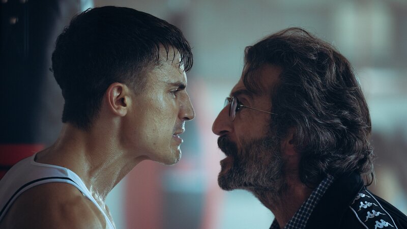 Nando (Álex González, l.) träumt von einer Karriere als Profiboxer, doch sein Trainer (Luis Zahera, r.) ist überzeugt, dass er dafür zu alt sei. Zwischen ihnen entbrennt ein hitziger Streit. – Bild: ZDF und FICCIÓN PRODUCCIONES