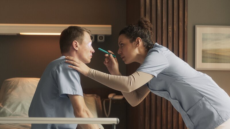 Schwester Carla (Haley Louise Jones, r.) untersucht Pfleger Vincent (Vincent Krüger, l.). – Bild: ZDF und X Filme/​Julia Jalnasow