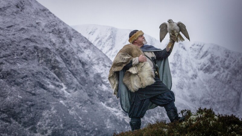 Ein Reanactor-Wikinger und ein Gerfalke (Gyrfalcon) in der verschneiten Landschaft des Alladale Naturschutzgebiet in Schottland. – Bild: ZDF