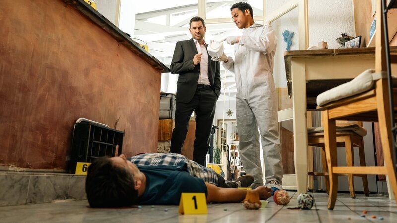 Rechtsmediziner Dr. Makena (Stephen Appleton, r.) und Kommissar Jonas Fischer (Lukas Piloty, M.) nehmen am Tatort die Ermittlungen auf. Wie sich herausstellt, führte David Meyer (Florian Odendahl, l.) eine Internet-Plattform, auf der sich Menschen treffen können, die gemeinsam ein Kind bekommen möchten, ohne eine Liebesbeziehung zu führen. – Bild: ZDF