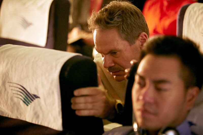 Nachstellung – Michael Hatton (Thom Vernon) nimmt kurz vor dem Absturz des Garuda-Flugs 200 eine Sicherheitshaltung ein. – Bild: Cineflix /​ Ian Watson