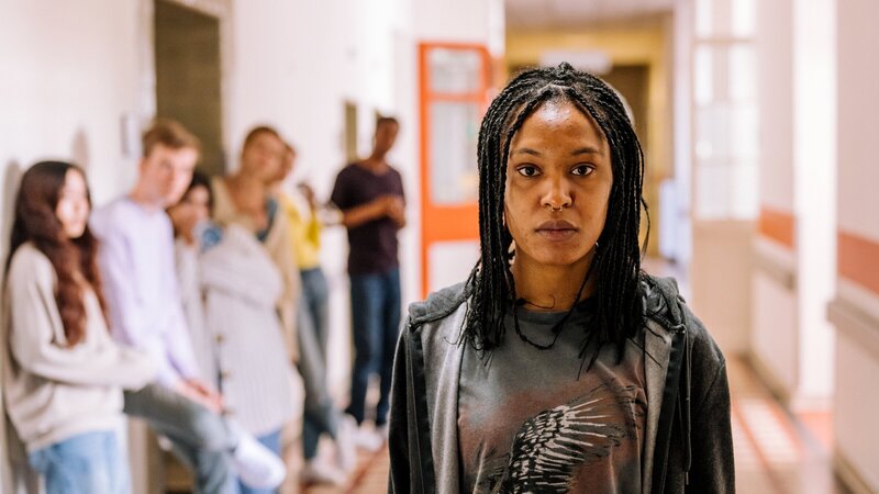 Ronnie (Zoe Magdalena) weigert sich, sich wiegen zu lassen und geht an der Warteschlange vorbei. Kurz darauf fällt sie in Ohnmacht. – Bild: ZDF