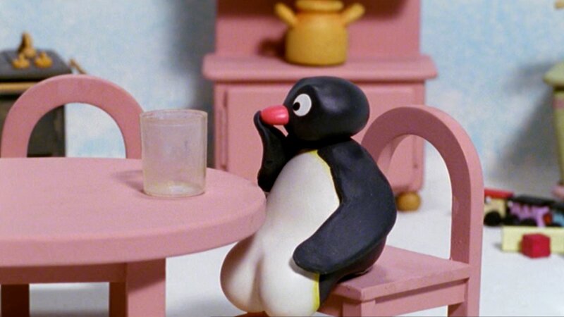 Guetnachtgschichtli Pingu Staffel 5 Folge 12 Pingu – Schluckauf Pingu sitzt am Tisch. – Bild: SRF/​Joker Inc., d.b.a., The Pygos Group