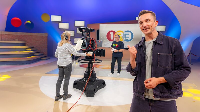 Wie geht Fernsehen? „PUR+“-Moderator Eric Mayer r.) ist bei der Aufzeichnung der Quizshow „1, 2 oder 3“ mit Moderator Elton (M.) dabei und findet heraus, was für eine gelungene Fernsehshow alles nötig ist. – Bild: Ralf Wilschewski /​ ZDF