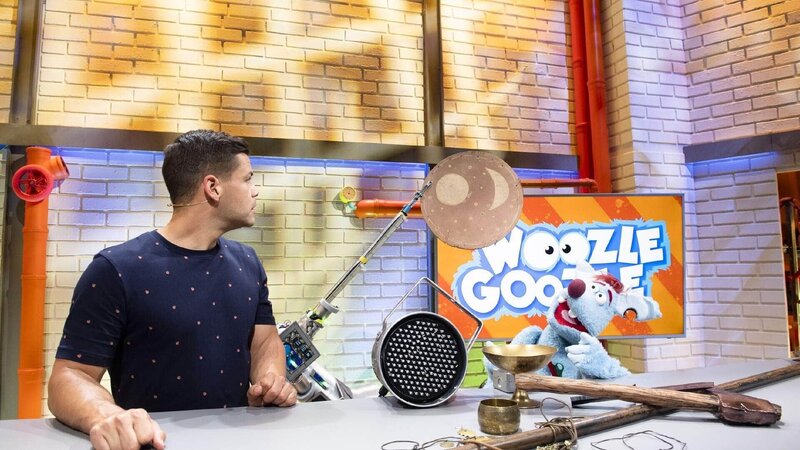Woozle (re.) ist Erfinder und Wissenschaftler – und er ist ein vorlautes, blaues Beuteltier mit einer Vorliebe für alles, was explodieren kann. Gemeinsam mit seinem besten Freund moderiert er ein Wissensmagazin für Kinder. Um einem Thema näherzukommen, hat Woozle aber sehr eigene Wege. Immer ist er am Tüfteln, Erfinden und Sachensprengen. Gemeinsam mit Simón (li.) geht er heute dem Thema Archäologie näher auf den Grund. – Bild: Annette Etges/​SUPER RTL