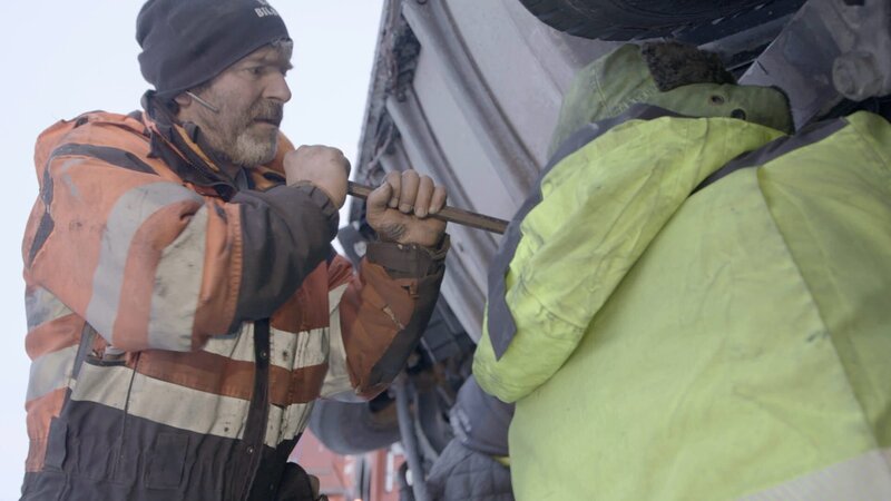 Bjoern hilft mit einem Brecheisen beim Ausbau der Antriebswelle. – Bild: National Geographic for Disney /​ Disney