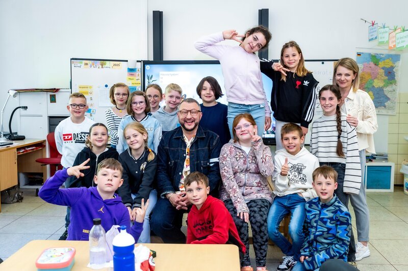 ZDFbesseresser Sebastian Lege inmitten von Kindern der Klasse 4a der Wilhelm-Lehmbruck Grundschule in Dorsten – Bild: Katja Inderka /​ ZDF
