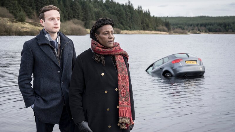 DCI Ellis (Sharon D Clarke) und ihr Kollege DS Harper (Andrew Gower) bei ihrem ersten gemeinsamen Fall: Ein junger Mann ist in seinem Auto gestorben, seine Freundin verschwunden. – Bild: ZDF