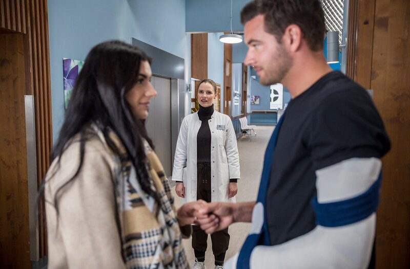 Dr. Julia Berger (Mirka Pigulla, M.) staunt nicht schlecht als Sie Donnie Gaus (Max König, r.), sich von einer ihr unbekannten Frau (Komparsin, l.) verabschieden sieht. – Bild: ARD/​Michael Kremer
