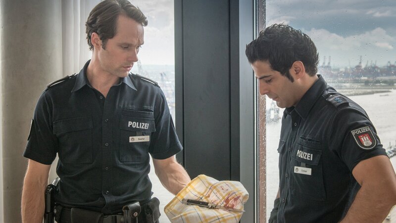 Die Beweise gegen Melanies Vater verdichten sich immer mehr. Mattes (Matthias Schloo, l.) und Tarik (Serhat Cokgezen, r.) haben das Tatmesser in seinem Hotelzimmer gefunden. – Bild: ZDF