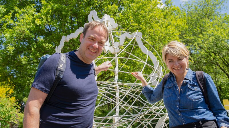 Sabine Heinrich (r) wandert mit Kollegen Fabian Raphael zum Mittelpunkt von NRW in Dortmund-Aplerbeck. – Bild: WDR/​Klarlogo