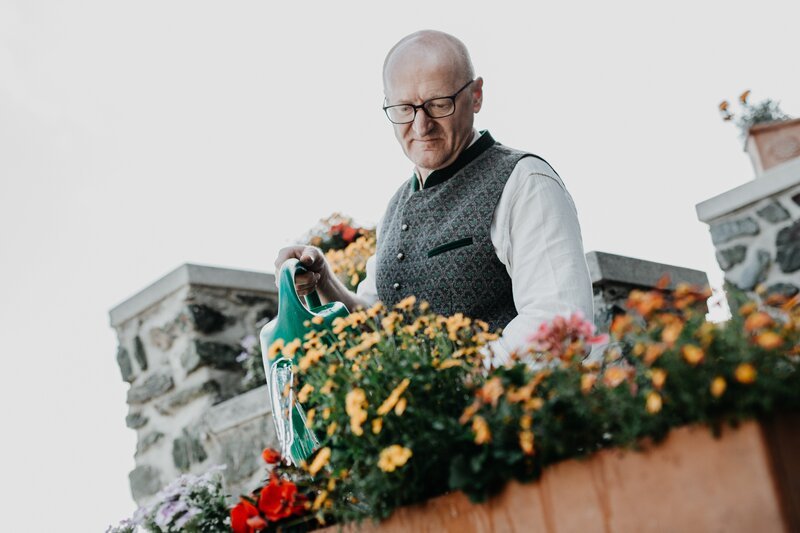 Norbert Steiner beim Blumengießen an seinem Hotel Looshaus am Kreuzberg – Bild: Christopher Kelemen /​ ServusTV