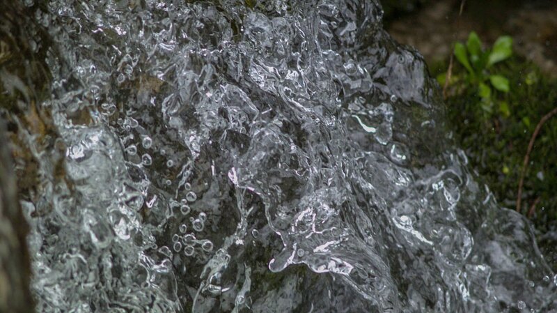 Die Dynamik der Alpenflüsse bricht die Oberflächenspannung, setzt Tropfen wieder frei und lässt feinen Wasserstaub sogar wieder in die Luft verdunsten. – Bild: BR/​Udo A. Zimmermann