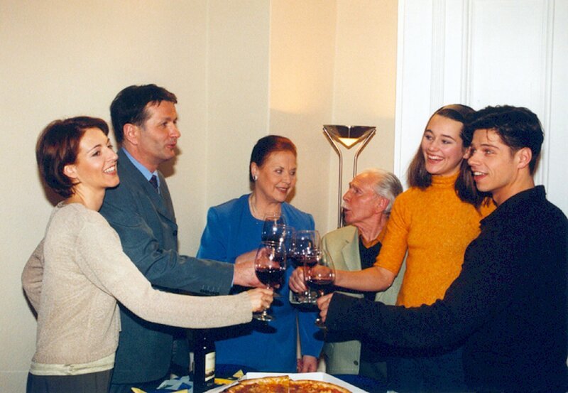 Vladi (Stephen Dürr, rechts) will mit einer heimlich vorbereiteten Einweihungsfeier ihrer neuen Wohnung Alina (Alissa Jung, 2.v. rechts) versöhnlich stimmen und stoßen mit Opa Friedrich, Charlotte, Roland und Pia (von 3. v. rechts nach links) auf das eigene Nest an. – Bild: NDR/​MDR/​Laue