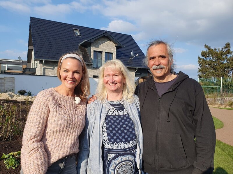 Gabriele (M.) und Titus Graf (r.) aus Bergheim haben einen Garten auf verschiedenen Ebenen. Oben wünscht sich das Paar eine Sitzecke mit Wasserlauf und Feuerstelle, unten soll es vor allem blühen. Eva Brenner (l.) bittet die Gartenprofis Frank Reise und Frank Egger Konzepte zu entwickeln, die daraus ein stimmiges Gesamtbild machen. – Bild: ZDF