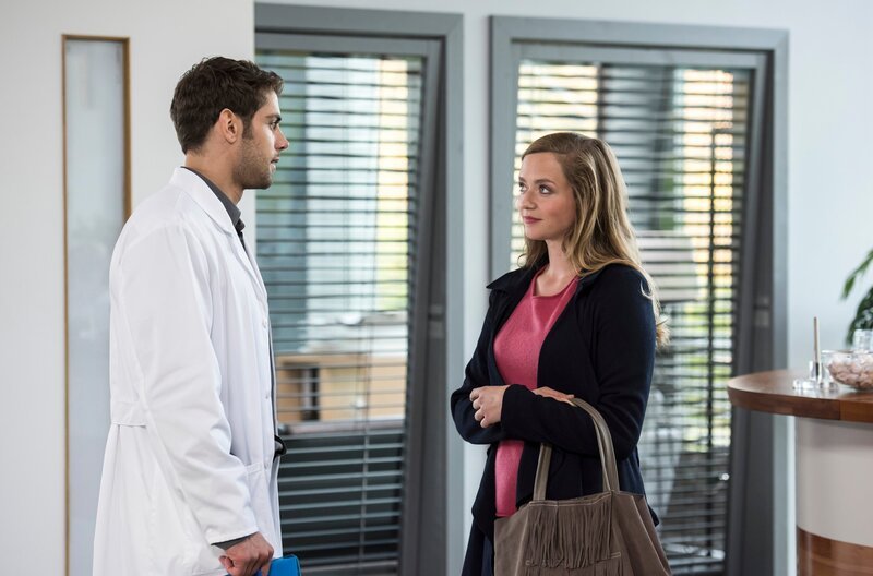 Eva (Sarina Radomski, r.) will auf Niklas’ (Roy Peter Link, l.) Angebot der Klinikführung zurückkommen und ist erstaunt, dass er Dr. Ahrend ist. – Bild: ARD/​Jens Ulrich Koch