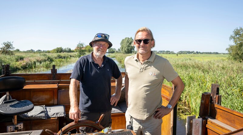 WDR Fernsehen LECKER AN BORD, Folge 6 „Finale in Friesland“, am Montag um 20:15 Uhr. Veenhoop, Niederlande: Von Grou hat sich Frank Buchholz (r) auf den Weg zu einem Foodforest, also einem „essbaren Wald“ gemacht. Kurz vor dem Ziel hat ihn Gartenbesitzer Bert Dijkstra mit einem historischen Holzboot abgeholt. – Bild: WDR/​Melanie Grande
