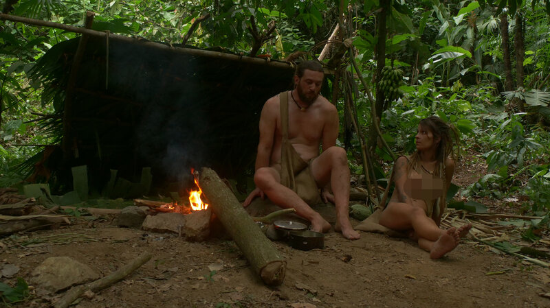 Kyle and Miranda sit outside their shelter and strategize about their next moves. – Bild: Discovery, Inc. und Warner Bros. Discovery, Inc.