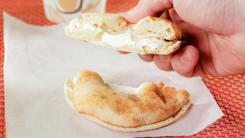 Bialy, ähnlich dem Bagel, das sind knusprige, zähe Brotscheiben, die mit Zwiebeln in der Mitte gebacken und oft mit Frischkäse serviert werden, hier von „Bell Bialy & Bagel“ in Brooklyn. – Bild: ORF/​Warner/​The Travel Channel