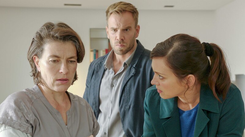 Am Tag nach ihrer Geburtstagsfeier macht Juliane Schöller (Jule Gartzke, l.) in ihrem Garten eine grauenvolle Entdeckung. Am frühen Morgen wurde dort ihr Ehemann Falk mit einem Kabel erdrosselt. Die Frau steht völlig unter Schock, Lars Pöhlmann (Dominic Boeer, M.) und Karoline Joost (Nike Fuhrmann, r.) sind bei ihr. – Bild: ZDF und Marc Meyerbroeker