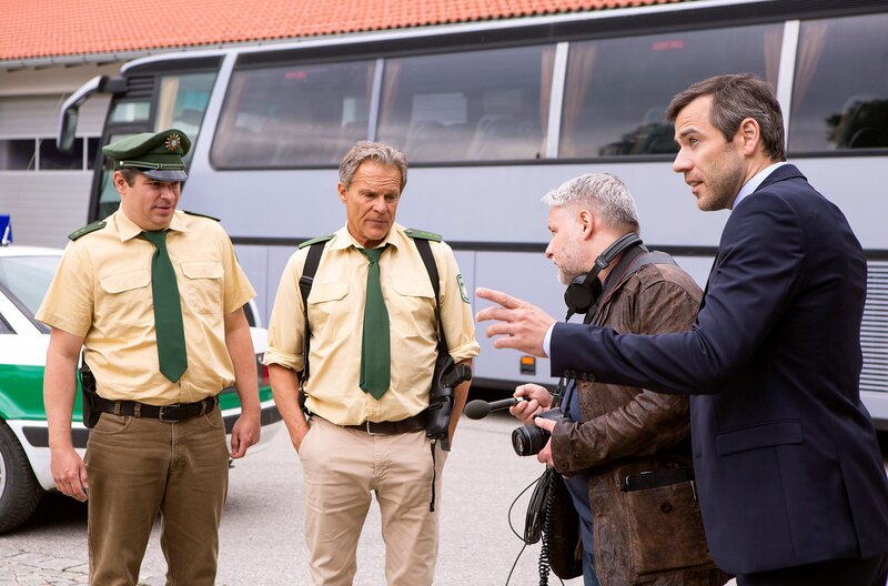 Hubert (Christian Tramitz, 2.v.l.) und Riedl (Paul Sedlmeir, l.) platzen in die Firmenübergabe von Thomas Brenner (Andreas Thiele, r. mit Komparse, 2.v.r.). – Bild: ARD/​BR/​Kai Neunert/​Kai Neunert