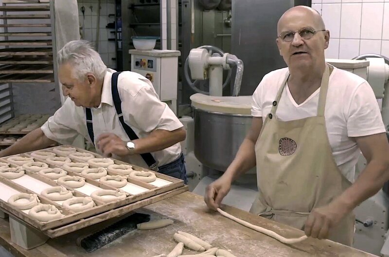 Arnd (re.) übernahm von seinem Vater (li.) die traditionsreiche Backstube: Noch heute arbeiten sie zusammen, zum Beispiel beim Brezeln backen. – Bild: zeroone/​Thomas Ridelsheimer