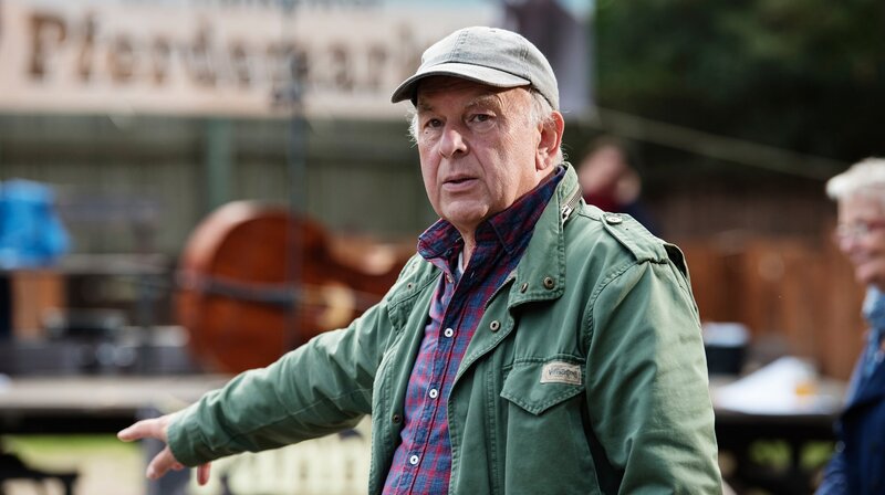 „Warum kann nicht einfach alles so bleiben, wie es ist?“ fragt Krause am Anfang der Geschichte. Empört realisiert er beim Sonntagsessen, dass Paula (Pauline Knof) die Speisekarte des Gasthofs verändert hat und nun vegetarische Speisen anbietet. Wütend reagiert er auf Bürgermeister Stübners (Boris Aljinovic) Idee, Schönhorst zu einem Urlauberdorf umzugestalten. Staatssekretärin Hummel (Rosa Falkenhagen) hat ein Auge auf Krauses Weiden geworfen – ein idealer Standort für Windräder. Alle im Ort sprechen von der Zukunft, haben sich alle gegen Krause verschworen? – Drehbuchautor und Regisseur Bernd Böhlich – Bild: rbb/​ARD Degeto/​Arnim Thomaß