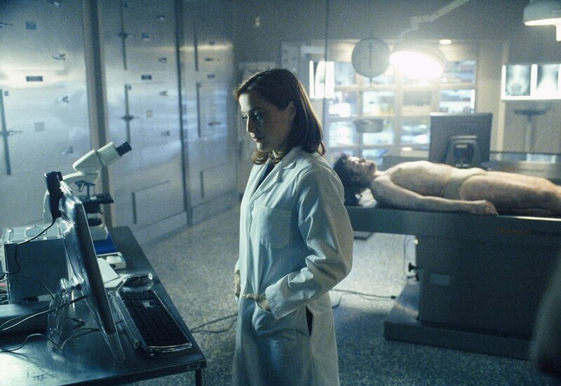 Dana Scully (Gillian Anderson) untersucht die Leiche eines jungen Mannes, der vom Himmel gefallen und auf dem Autodach seines Freundes gelandet ist. – Bild: Twentieth Century Fox Film Corporation