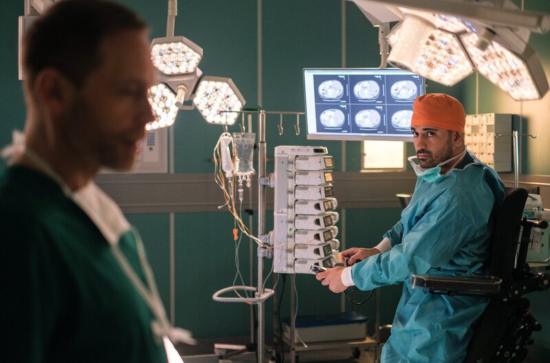 Dr. Kai Hoffmann (Julian Weigend, li.) benötigt dringend den OP und Dr. Ilay Demir (Tan Caglar, re.) ist immer noch drin. Sein OP-Rollstuhl funktioniert nicht mehr. Doch Dr. Kai Hoffmann interessiert nur, ob Dr. Demir so trotzdem operieren kann. – Bild: MDR/​Saxonia Media/​Robert Strehler