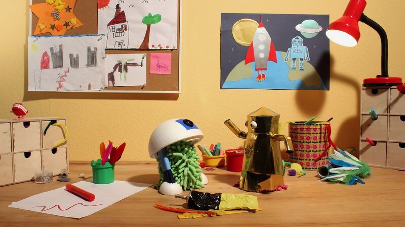 Wisch und Mop spielen auf dem Basteltisch. – Bild: NDR/​Trikk17