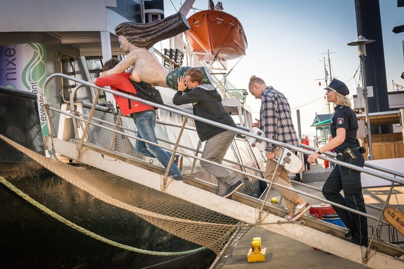 Melanie (Sanna Englund) und Mattes haben Paul Heffner (Cecil von Renner, l.) und seine Freunde aufgegriffen, als sie die Galionsfigur der „Elbnixe“ stehlen wollten, und begleiten die drei zurück aufs Schiff, wo sie die Dame wieder an ihrem Platz anbringen dürfen. – Bild: ZDF und Boris Laewen