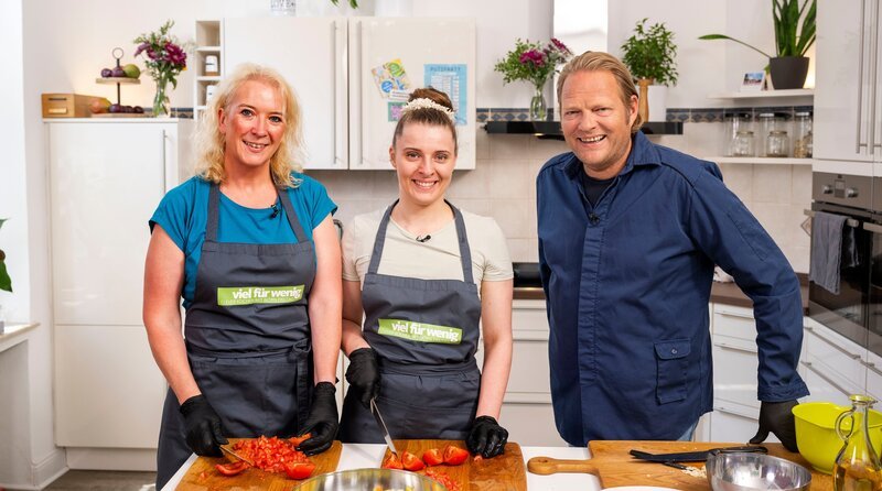 Im Haus HuMy! in Mülheim an der Ruhr kochen die Mitarbeiterinnen Alexandra Laps und Larissa Stermann (M) mit Björn Freitag (r). – Bild: WDR/​Melanie Grande
