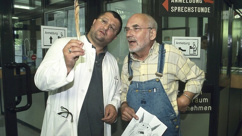 Mit Hilfe der gefundenen Feder erkennt der Tierarzt (Aykut Kayacik, l.), dass der „Kobold“ im Garten von Peter (Peter Lustig, r.) ein Uhu sein muss. – Bild: ZDF und Christiane Pausch