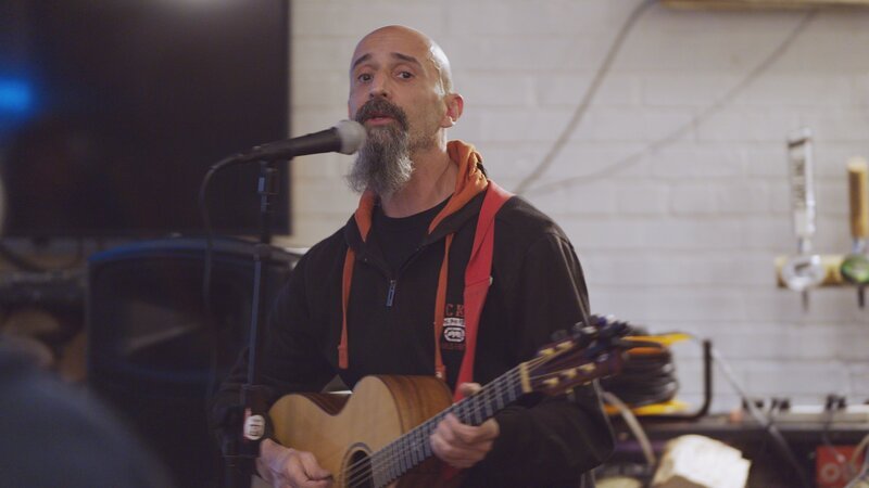 Manche versinken so tief in Verschwörungen, dass diese ihr gesamtes Denken und Handeln beeinflussen. Der Engländer Darren Smith bringt die Truther Zeitung „The Light“ heraus und tourt als Protestsänger von einer Demo zur nächsten. – Bild: Jean Schablin /​ ZDF