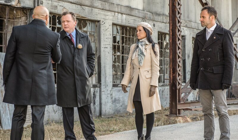 Capt. Gregson (Aidan Quinn, 2.v.l.), Dr. Watson (Lucy Liu, 2.v.r.) und Sherlock Holmes (Jonny Lee Miller, r.) lernen Moriartys Gefängniswärter Ramses Mattoo (Faran Tahir, l.) kennen und erfahren, dass er schwul ist – man hat ihn bewusst ausgewählt, damit er Moriartys Verführungskünsten nicht zum Opfer fallen kann. Doch reicht dieser Schachzug aus, um Mattoo vor ihren Tricks und Spielchen zu schützen? – Bild: CBS Television