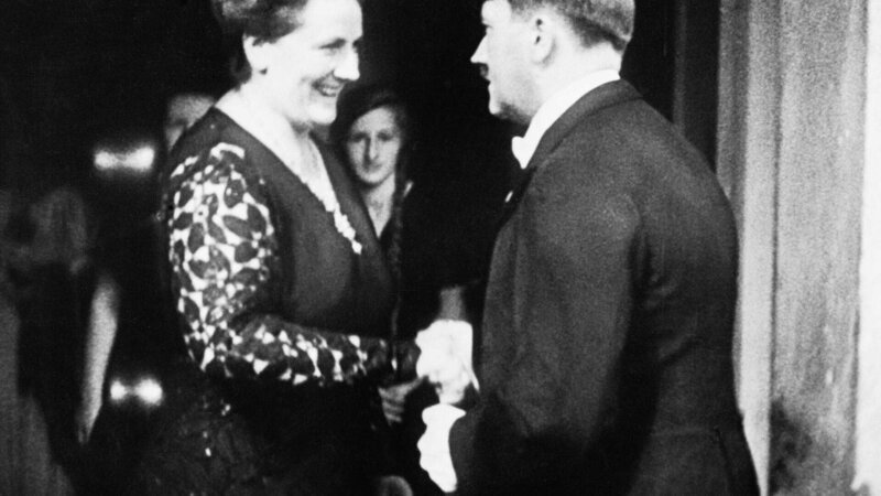 Adolf Hitler (1889⁠–⁠1945) wird in Bayreuth von seiner engen Freundin Winifred Wagner begrüßt. (1934) – Bild: TVNOW /​ Bettmann Archive