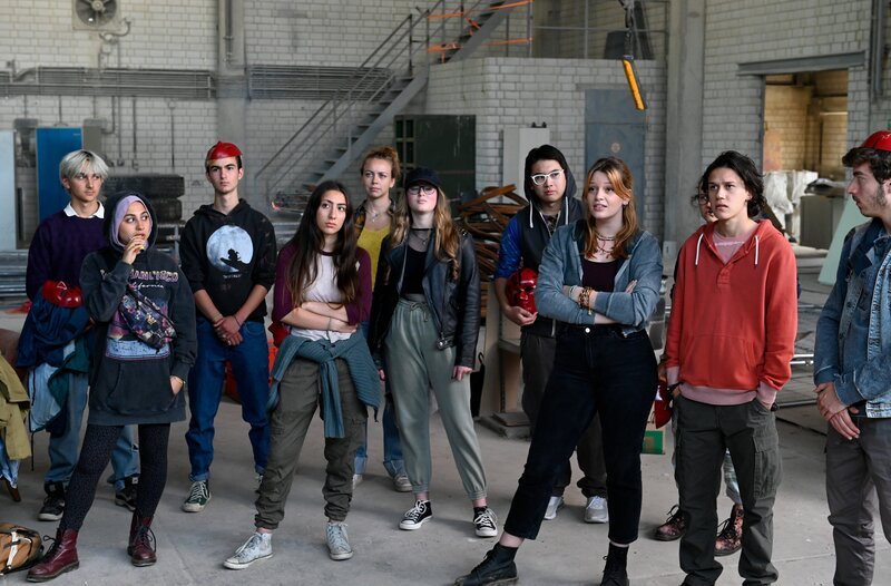 Die „Retter der Welt“ sind sich uneins, ob sie jetzt auch Gewalt bei ihren Aktionen anwenden wollen. Mit dabei: Niklas Fehrenbach (Noah Calvin, 2.v.r.), Lilly (Charlotte Dreesen, 3.v.r.) und Kisha (Tua El-Fawwal, 2.v.l. mit Kompars:innen). – Bild: ARD/​Laurent Trümper