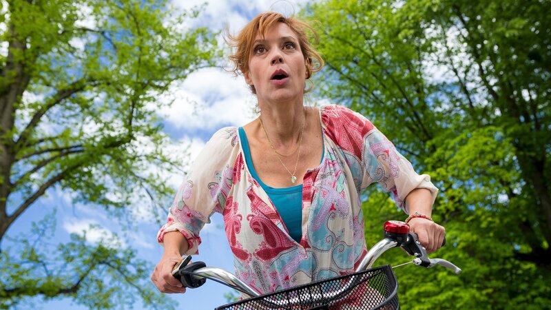 Die quirlige, alleinerziehende Mutter Eva Sellgren (Carin C. Tietze) ist gern mit dem Rad unterwegs. Hier allerdings hebt sie gewissermaßen ab, nachdem sie Kristian Nordens Auto ausweichen muss. – Bild: ZDF