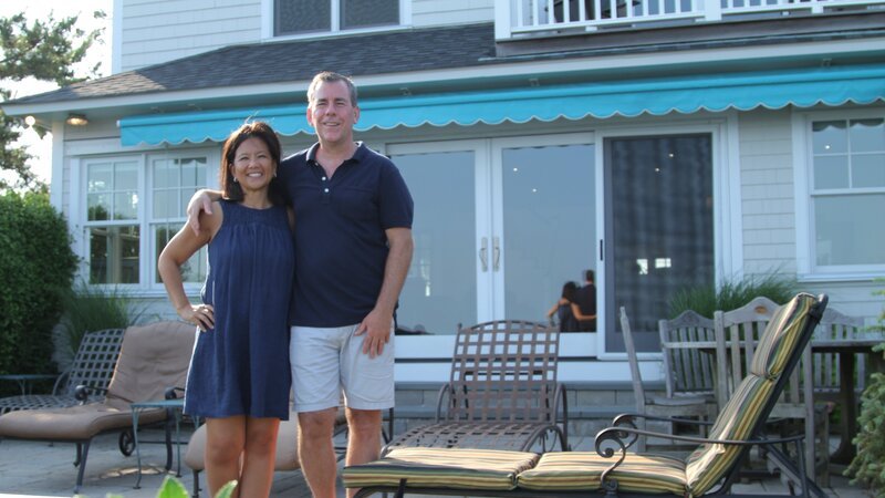 Homebuyers Anna Maria and Jim pose for a photo outside the Seawall House, as seen on HGTV’s Beach Hunters. – Bild: Warner Discovery Inc
