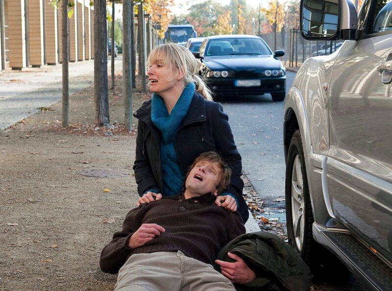 Tobias Metzer (Kai-Peter Gläser) hat nach einem Streit mit seiner Frau Nina (Sarah Becker) wutentbrannt die Klinik verlassen. An seinem Wagen bricht er zusammen – er hat einen zweiten Anfall, der ihn fast das Leben kostet. – Bild: MDR/​MDR/​Peter Krajewsky