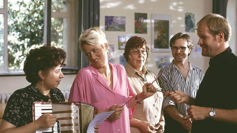 Ritas (Gaby Köster, 2.v.l.) alter Trinkkumpel Klaus Brettschneider (Guntbert Warns, r.) ist der Pfarrer, der die Kommunionsfeier für Ritas Sohn Markus gestaltet. Mit Unterstützung von Gisi (Franziska Traub, l.) bringt er Rita dazu im Kirchenchor mitzusingen. – Bild: MG RTL D /​ Martin Lässig