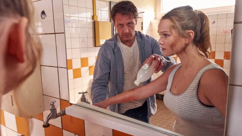 Stefan Vollmer (Hendrik Duryn) will Klaras (Sofie Eifertinger) Wunde versorgen und sieht ihre Narben … – Bild: TVNOW /​ Frank Dicks