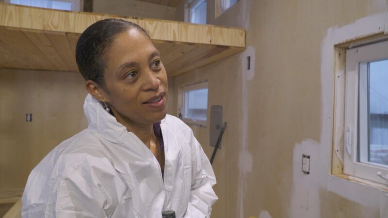 Nadia lebt mit Tochter Gina in Atlanta, Georgia, in einem 160 qm-Haus mit zwei Schlafzimmern, drei Bädern und offenem Wohnkonzept. Doch Gina wird in wenigen Jahren aufs College gehen, und Nadia braucht alleine nicht so viel Platz. Außerdem möchte sie in Zukunft viel reisen und hat deshalb beschlossen, ihre üppigen 160 qm gegen ein Tiny House einzutauschen. Ihr künftiges Mini-Domizil soll knapp 28 qm groß werden, nicht mehr als 50.000 Dollar kosten und binnen 12 Wochen fertig gebaut sein. Doch Nadias Ansprüche an die Einrichtung sind hoch: ein Meditationsraum, ein Ankleidebereich, ein schickes Bad und ein Schlaf-Loft mit Queen-Size-Bett müssen sein. – Bild: HGTV