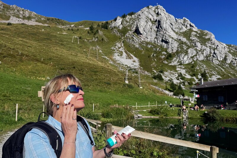 Puls – Hautkrebs durch Bergsonne - Das UV-Risiko wandert mit. 'Puls'-Host Daniela Lager trägt in den Bergen grosszügig Sonnencreme auf. – Bild: SRF1