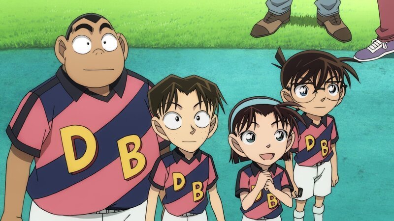 Conan (r.), der gemeinsam mit den Detective Boys die Mannschaft der Tokyo Spirits anfeuert, findet heraus, dass sich die Bombe im Stadion befindet. Wird er es schaffen, die die ahnungslosen Fans zu retten, bevor die Bombe gezündet wird? – Bild: GOSHO AOYAMA /​ DETECTIVE CONAN COMMITTEE